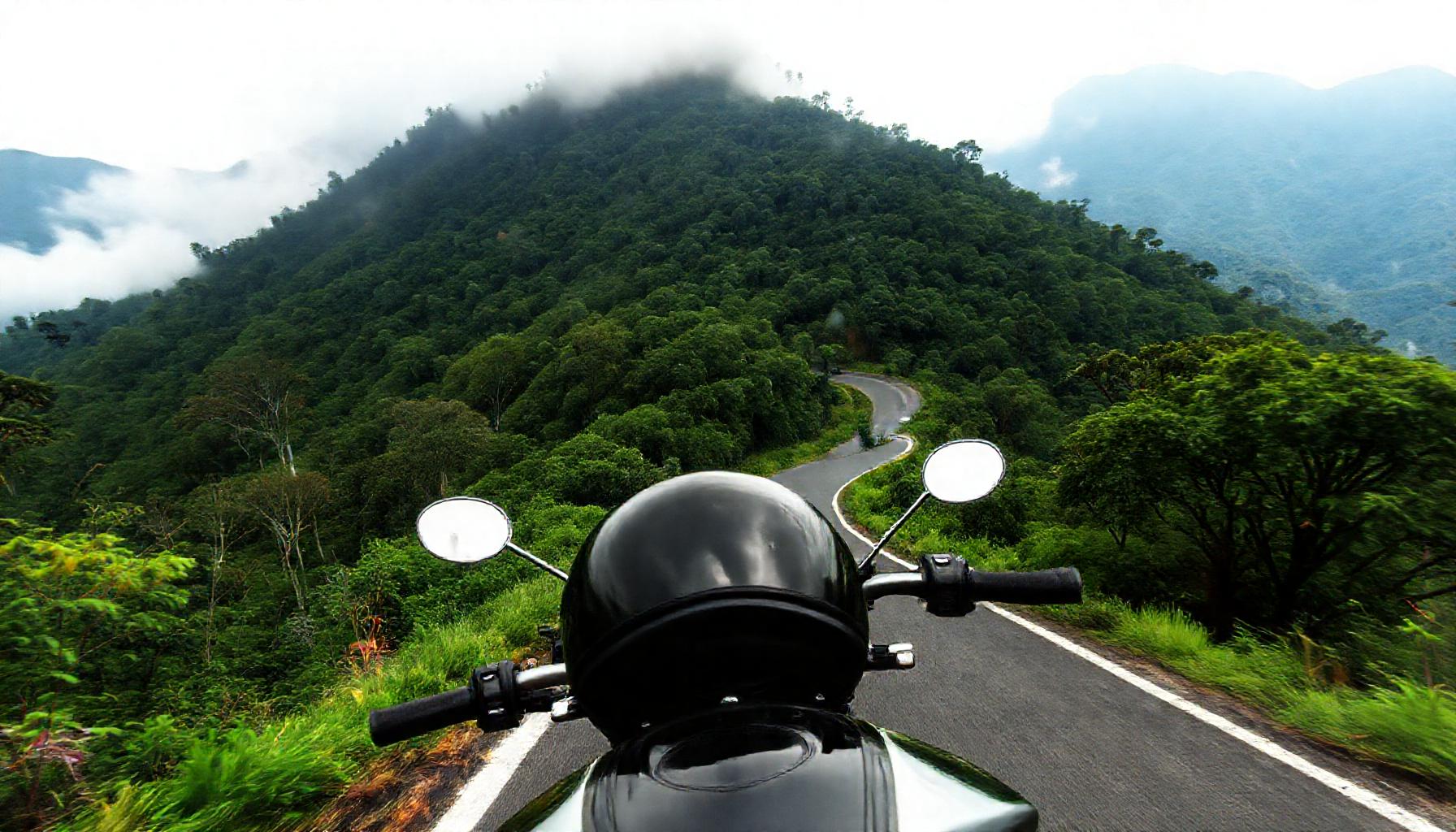 Moto em curva de estrada de serra com mata atlantica em Campos do Jordao Sao Paulo